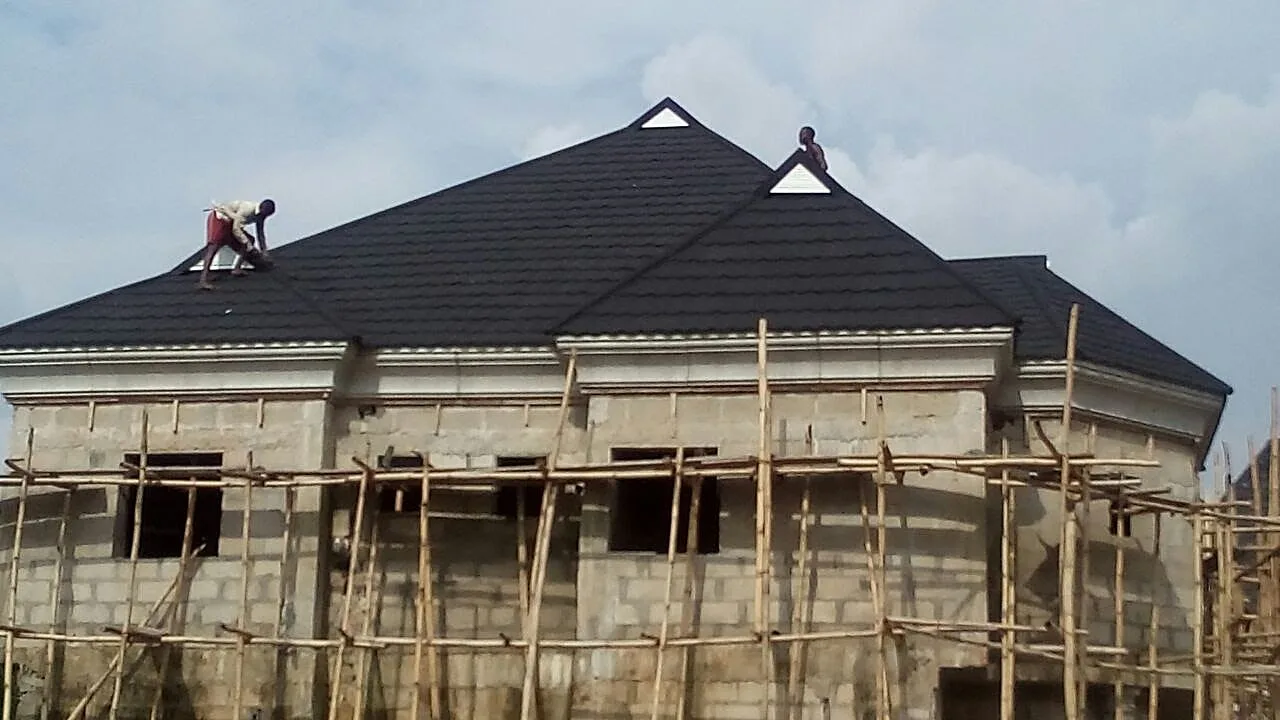Installer fitting stone-coated tile, bungalow